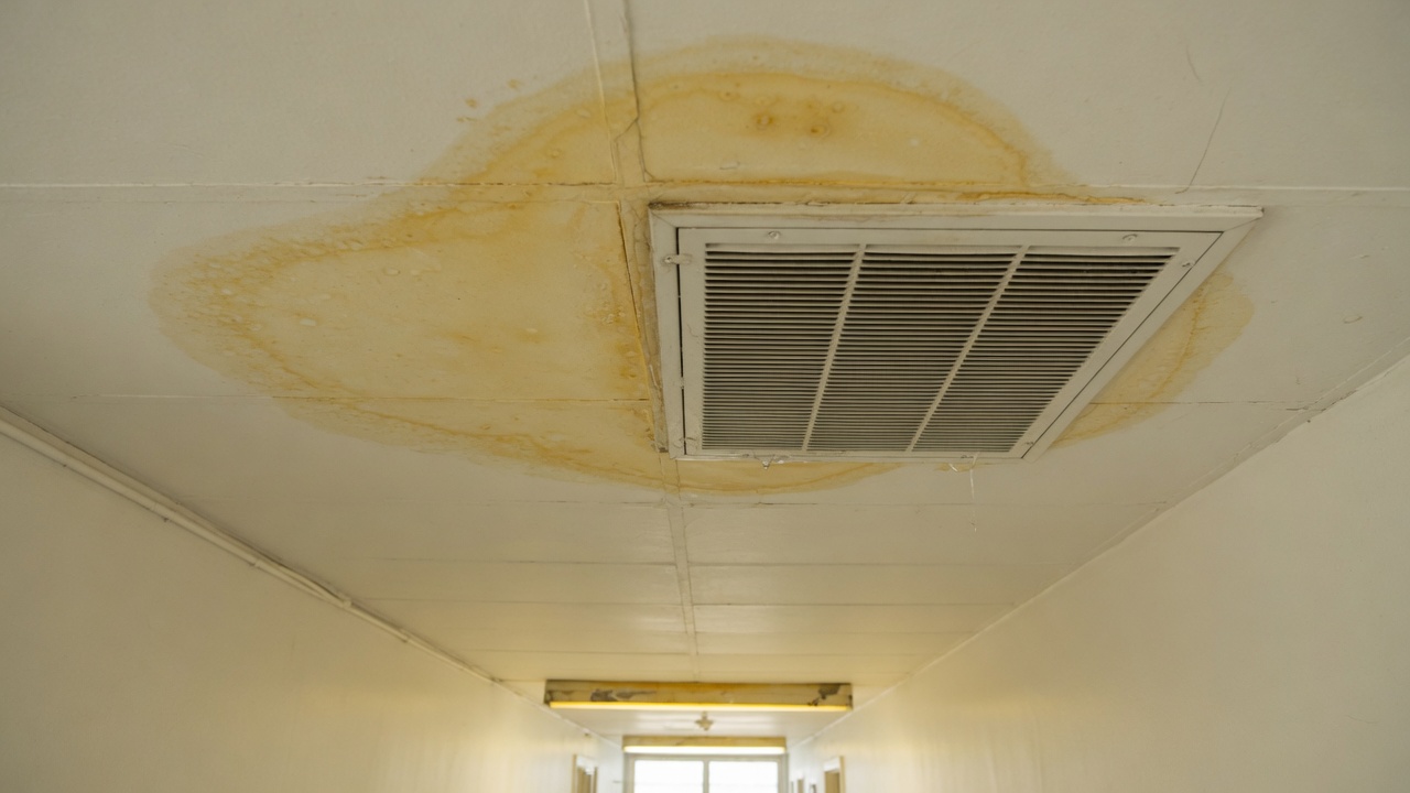 Water dripping from a ceiling air supply register onto a living room floor
