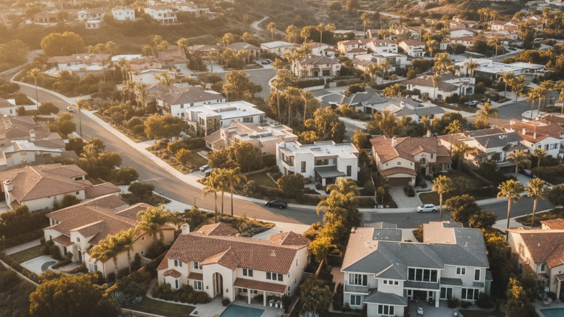Aerial view of a San Diego County residential neighborhood with stucco homes at golden hour